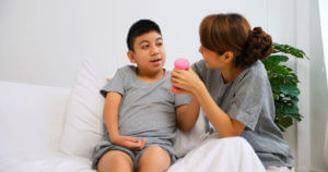 A child with cerebral palsy receives therapy through exercises with therapist support and care.