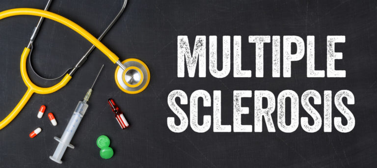 A stethoscope and various pharmaceuticals are displayed on a blackboard with the phrase Multiple Sclerosis written on it.