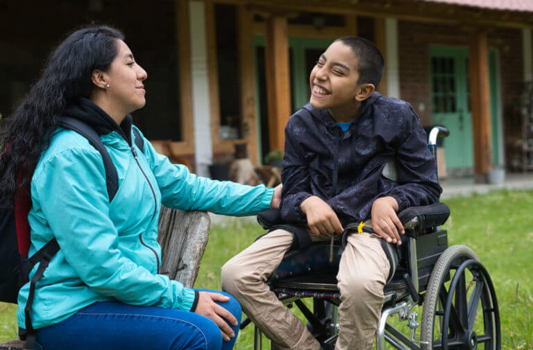 child with cerebral palsy smiling with his mother