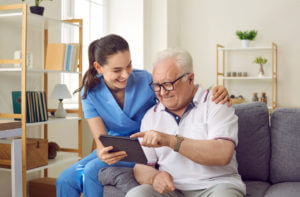 A female caregiver works with a senior man, guiding him through short-term memory exercises and offering supportive, attentive care.